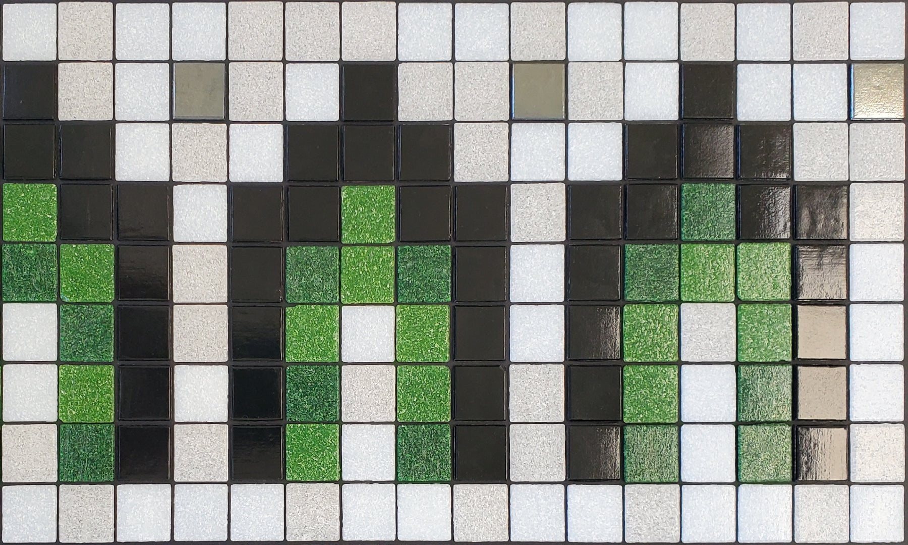 Marrakech AG - Moroccan-inspired glass mosaic waterline pool border tile - glossy black, green, white archways with metallic silver dot accents.