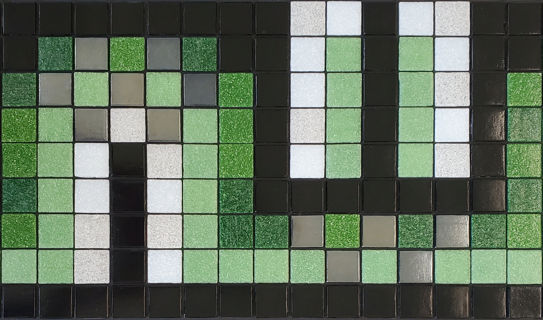 Peche AA - art deco-inspired glass mosaic waterline pool border tile - glossy black, white, green and metallic silver tiles dance in a flowing S-curve.