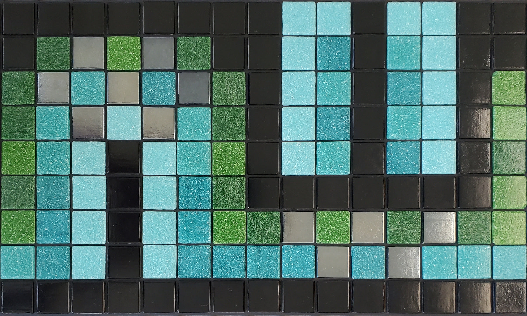 Peche AE - art deco-inspired glass mosaic waterline pool border tile - glossy black, light blue, green and metallic silver tiles dance in a flowing S-curve.