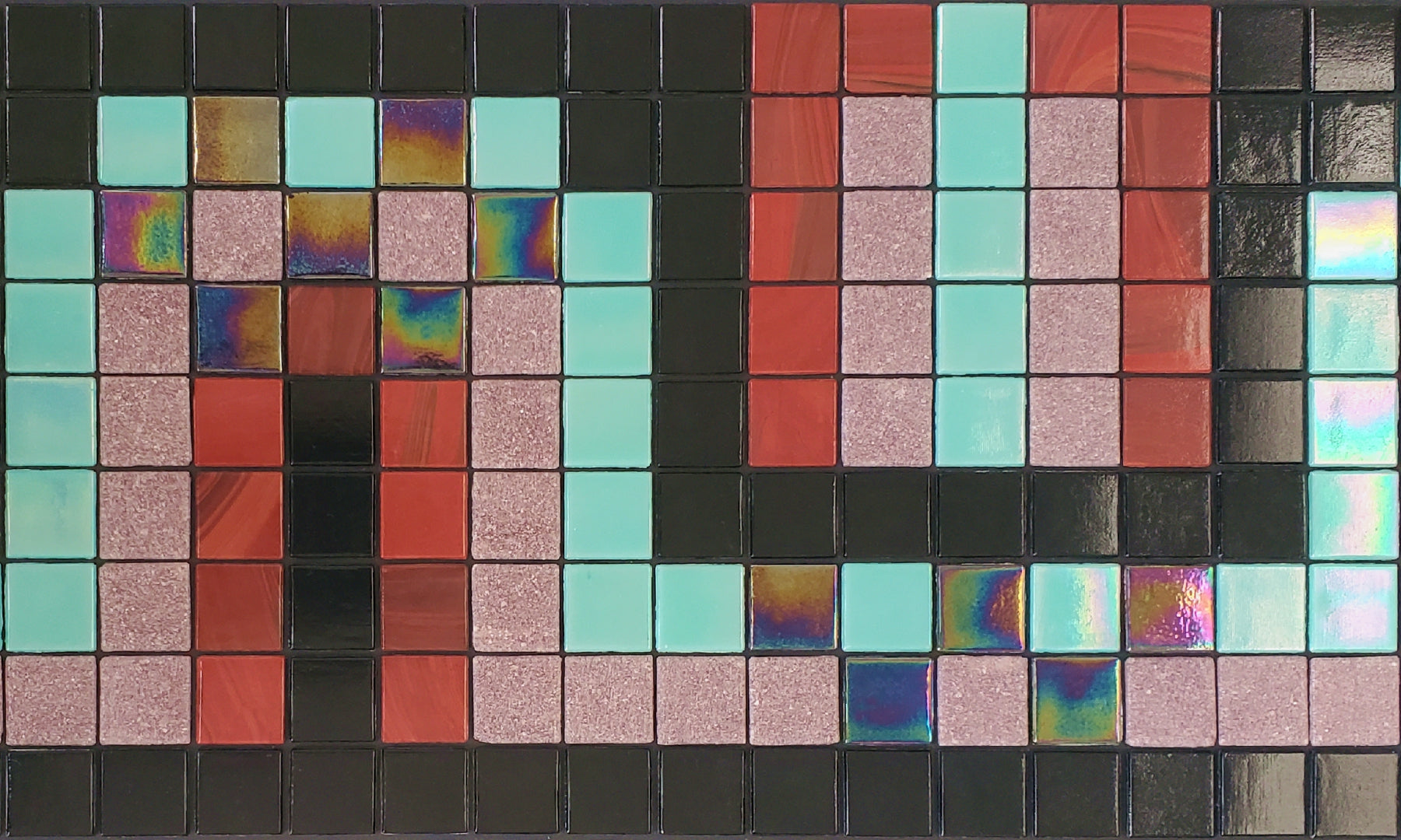 Peche H - art deco-inspired glass mosaic waterline pool border tile - shiny black, iridescent aqua, brick red, and pink tiles dance in a flowing S-curve.