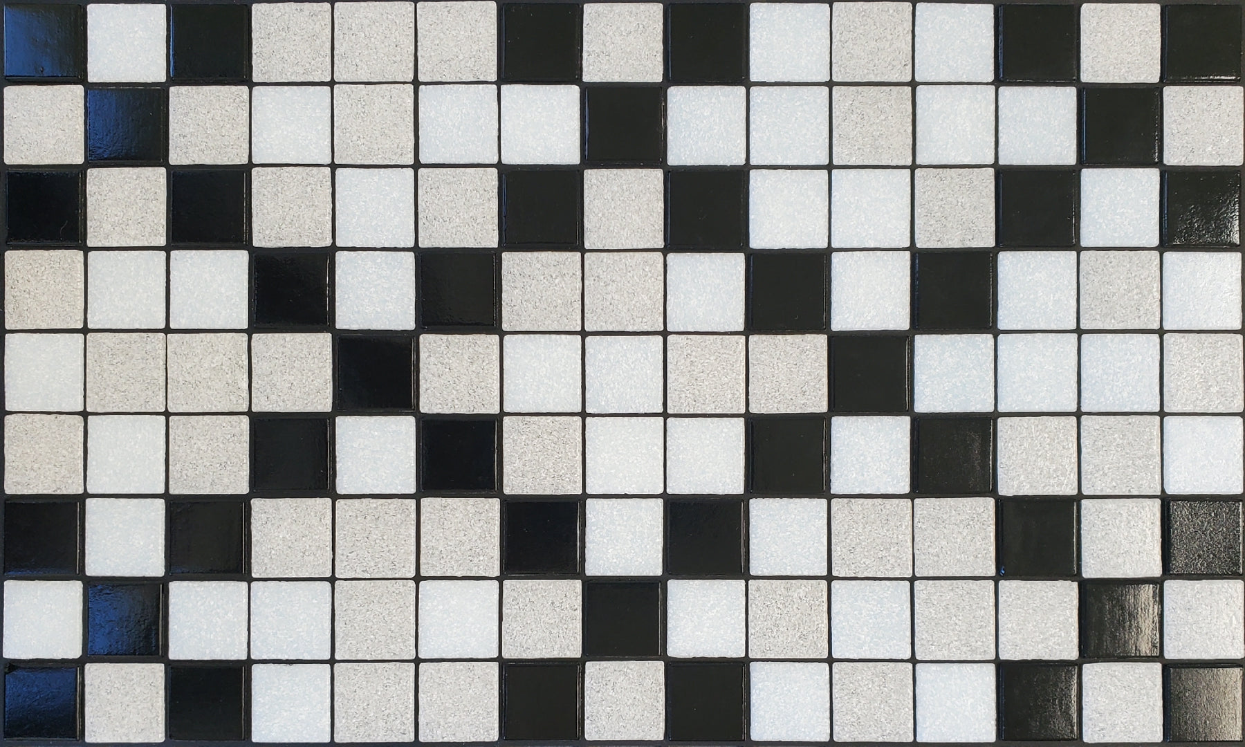 Souk I - Moroccan-inspired glass mosaic waterline pool border tile - glossy black and white tiles in an "x" pattern.